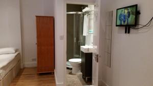 a bathroom with a sink and a toilet at Shepherd's Bush Flats in London