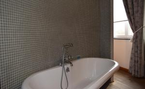 a bathroom with a bath tub with a shower at Oranje City Hotel in Diest