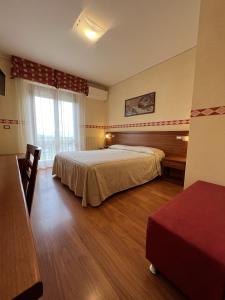 a hotel room with two beds and a window at Viole Country Hotel in Assisi