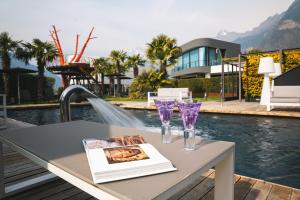 a table with two wine glasses and a book at Hotel Gartner in Tirolo