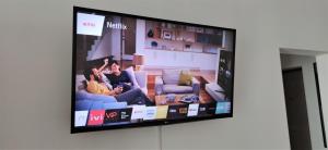 uma televisão de ecrã plano pendurada numa parede numa sala de estar em Loftik Apartments Abay street em Almaty