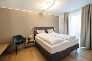 1 dormitorio con 1 cama grande y 1 silla en Residence aMoret en Bressanone