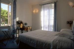 a bedroom with a bed and a desk and a window at Locanda Tramonti in La Spezia