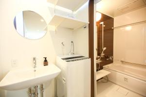 a white bathroom with a sink and a mirror at PrimeRoom別府 Root in Beppu