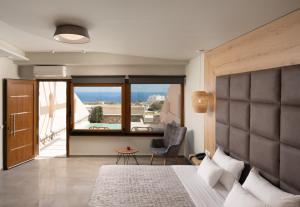 a bedroom with a large bed with a large window at Perla Nera Suites in Fira