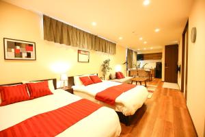 a hotel room with two beds and a living room at PrimeRoom別府 Root in Beppu