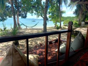 a balcony with a view of the ocean at Sabai Sabai Beach Bungalows in Ko Phayam