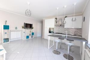 uma cozinha com armários brancos, uma mesa e bancos em Tuscany To Love - Holiday Home - Casa Vacanze em Pieve a Nievole