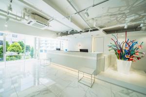 an office lobby with a reception desk and plants at Rembrandt Style Naha in Naha