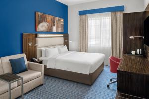 a hotel room with a bed and a chair at Holiday Inn Express Dubai Safa Park, an IHG Hotel in Dubai