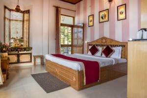 a bedroom with a large bed with pink and white stripes at Ram Cottage Chail 3 BHK villa with Lawn & Parking in Chail