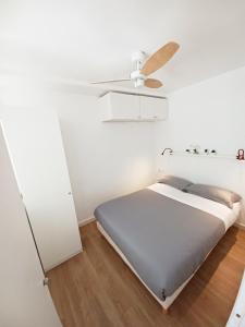 Schlafzimmer mit einem Bett und einem Deckenventilator in der Unterkunft Acogedor y luminoso apartamento muy cerca de la playa con parking gratis y piscina in Calella de Palafrugell