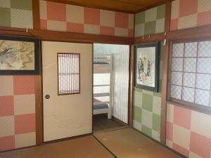um quarto com uma porta e uma cadeira em Surf Imin G-Sun em Wakayama