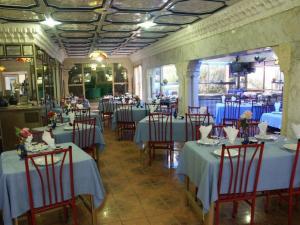 um restaurante com mesas e cadeiras com toalhas de mesa azuis em Hotel Hamilton em Hammamet