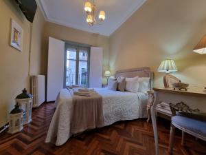 a bedroom with a bed with a table and a window at Casa de Lorca in Alcalá de Henares