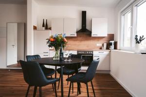 a kitchen with a table with chairs and flowers on it at Weingut Meurer in Reil