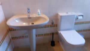 a bathroom with a white sink and a toilet at Es Jaç in Cala Santanyi +11 photos