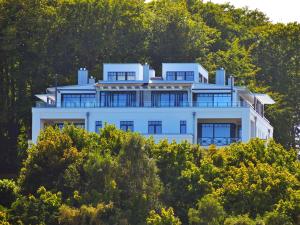 a large white house on top of a hill at Villa Claire - Meerblicksuite "Sunrise Queen" in Ostseebad Sellin