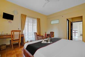 a bedroom with a bed and a desk and a television at The Fort Manor Hotel - Kochi Kerala in Fort Kochi