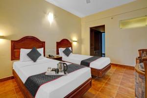 سرير أو أسرّة في غرفة في The Fort Manor Hotel - Kochi Kerala