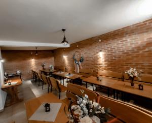 restauracja z drewnianymi stołami i krzesłami oraz ceglaną ścianą w obiekcie Wczasy od Maluszka do Staruszka w mieście Ryglice