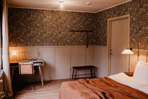 um quarto com uma cama e uma secretária na parede em Stiftsgården Tallnäs em Skillingaryd