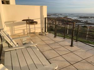 patio con mesa y sillas en el balcón en Aan’t See Apartment, en Lambertʼs Bay