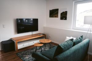 ein Wohnzimmer mit einem Sofa und einem Flachbild-TV in der Unterkunft Weingut Meurer in Reil