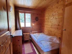 a small bedroom with a bed in a wooden cabin at Zer Tanna in Blatten bei Naters
