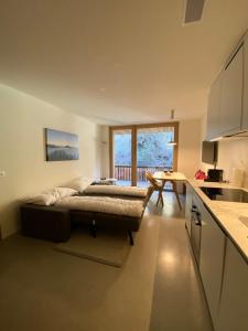 een slaapkamer met een bed en een keuken met een tafel bij Stilvolle Ferienwohnung direkt an der Skipiste in Flims
