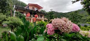 a house with pink flowers in front of it at Karthik Resorts, Jeolikote Nainital in Nainital