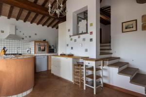 a kitchen with a counter and stairs in a room at Villa Montegemoli - by Bolgheri Holiday in Pomarance