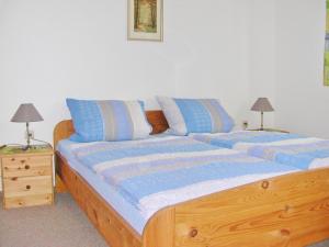 a bedroom with a wooden bed with blue pillows at Bungalow Möller in Dahme