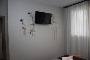 a flat screen tv on a white wall in a room at Le An Apartments Thalassa in Keramotí