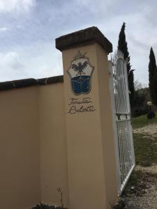 a white fence and a gate with a sign on it at Podere Poggio Lupinaio in San Martino