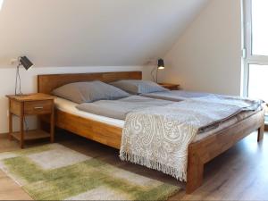 オストゼーバート・カールスハーゲンにあるFerienhaus Aurin AURIのベッドルーム1室(大型ベッド1台、木製ヘッドボード付)