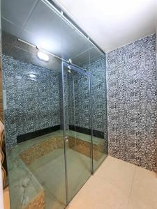 a shower with a glass door in a room at Diamond Star Hotel فندق النجمة الماسية in Seeb