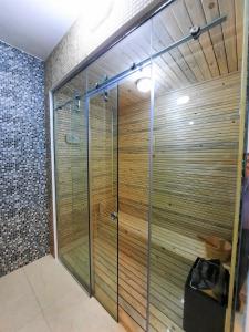 a shower in a bathroom with a wooden wall at Diamond Star Hotel فندق النجمة الماسية in Seeb