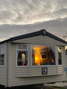 una pequeña casa con una gran ventana en ella en Deluxe 3 bedroom caravan in Haven's Seton Sands Holiday Village,Wifi, en Port Seton