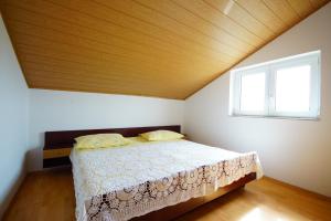 Schlafzimmer mit einem Bett und einem Fenster in der Unterkunft Apartmani Branka in Rtina