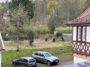 twee auto's geparkeerd op een parkeerplaats naast een huis bij Ferienwohnungen Historische Post in Bad Liebenstein
