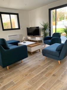 sala de estar con sofás azules y TV de pantalla plana en Maison contemporaine aux portes de Brest en Bohars