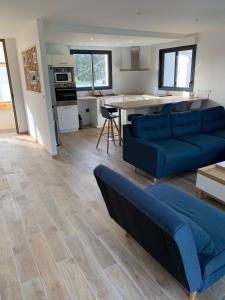 sala de estar con sofá azul y cocina en Maison contemporaine aux portes de Brest en Bohars