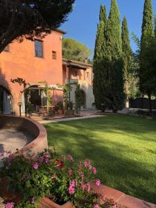 a garden area with a garden hose and a house at Borgo Dolciano in Chiusi