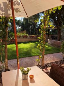 a patio area with a table, chairs, and umbrella at Borgo Dolciano in Chiusi