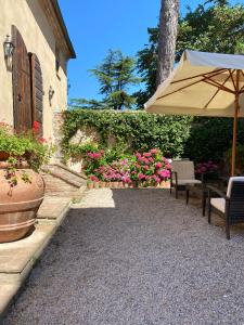 a patio area with a table and chairs with umbrellas at Borgo Dolciano in Chiusi