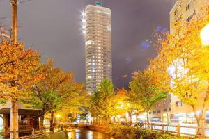 a tall building in a city at night with trees at Meteor Shower in Sapporo