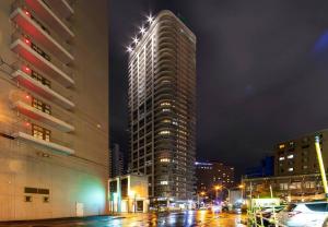 a tall building on a city street at night at Meteor Shower in Sapporo