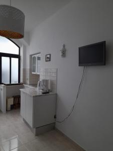a kitchen with a flat screen tv on the wall at Casa das Netas in Lagos