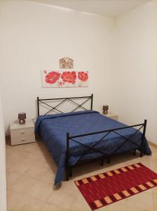 1 dormitorio con cama azul y alfombra roja en Casa Sole e Vento en Birgi Vecchi